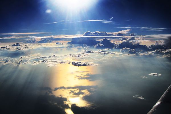 Blue sky with wispy clouds photographed from an airplane window