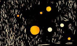 Woodcut-style print of glowing amber and white orbs scattered across a dark background with rough white hatching marks